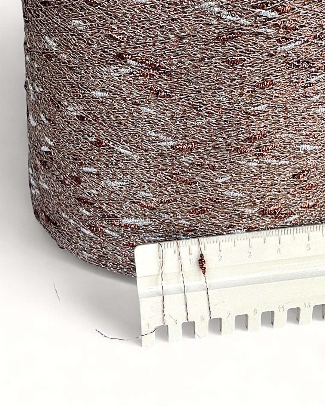 Textured brown fabric with a ruler for scale on a white background