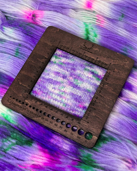 Soft and durable hand-dyed alpaca-merino-nylon yarn in a colorful mix of purple, green, white, and pink; perfect for knitting or crocheting projects