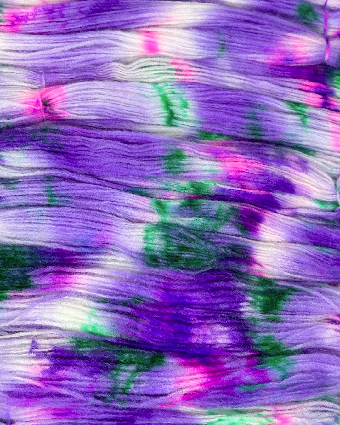 High-quality crafting yarn made from super baby alpaca wool blend with merino and nylon in eye-catching purple tones with splashes of green and pink