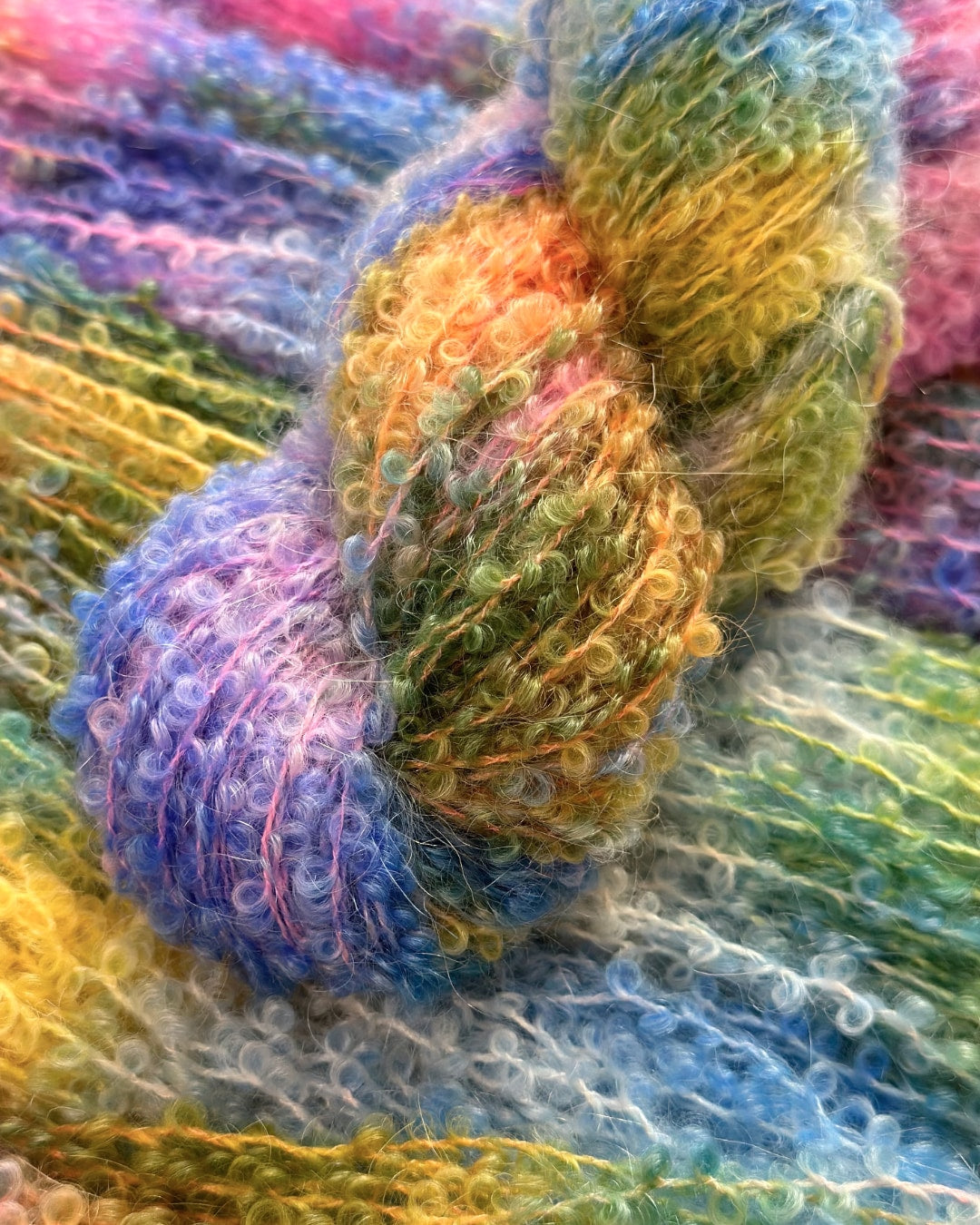 High-quality crafting yarn with a delicate mix of pastel blues to sunny yellows transitioning into warm pinks; 75% kid mohair, 25% silk.