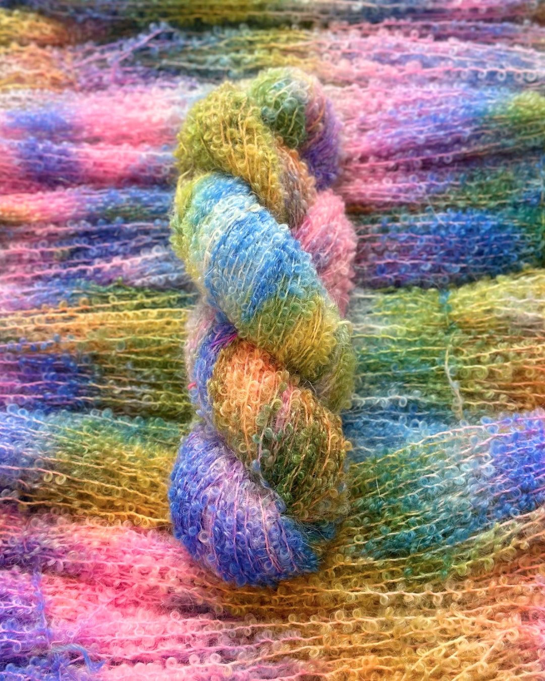 Luxurious kid mohair and silk blend yarn in a colorful gradient of blue, green, yellow, and pink, 250 meters per 100 grams.