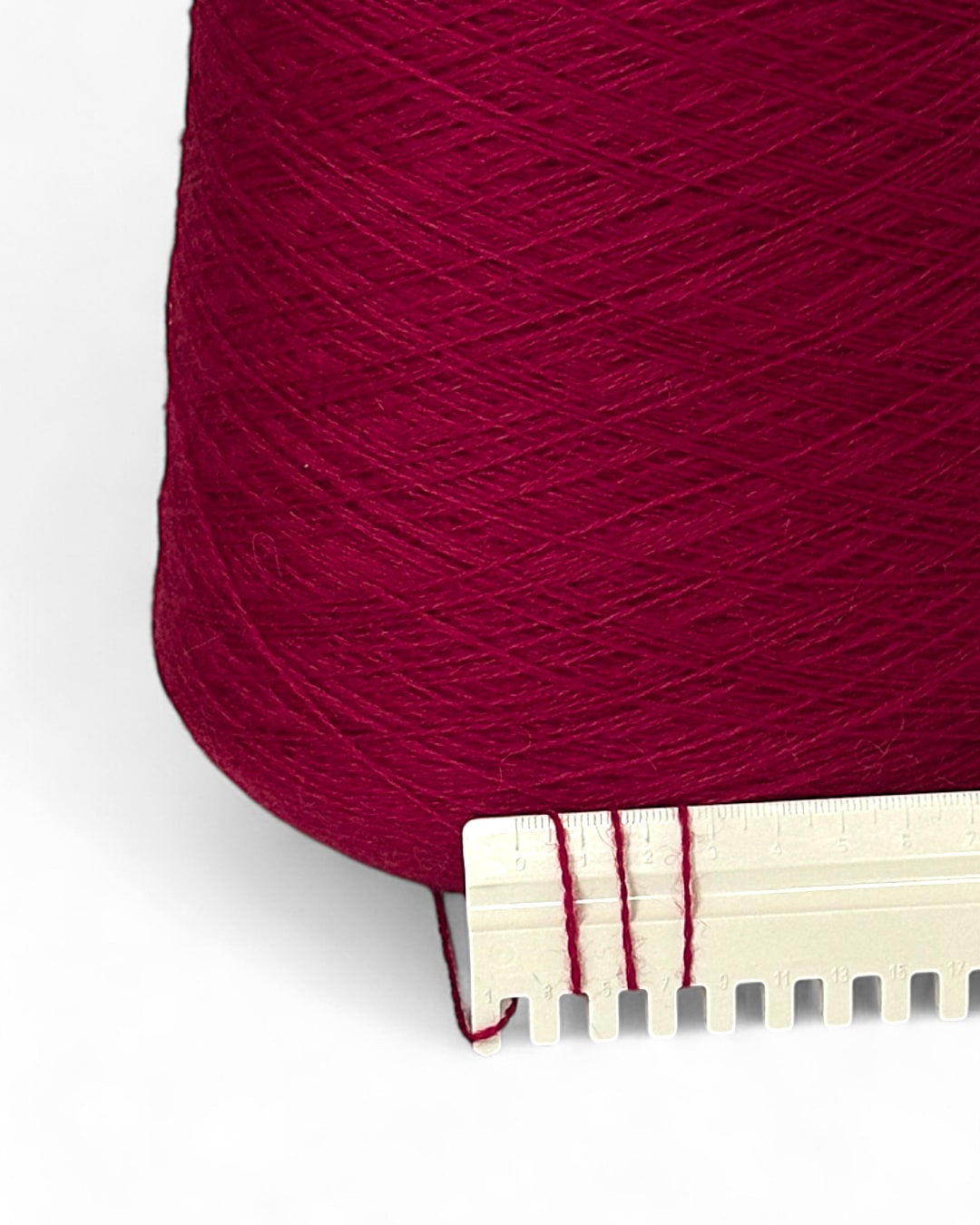 Cone of fine Italian yarn in rich raspberry tone