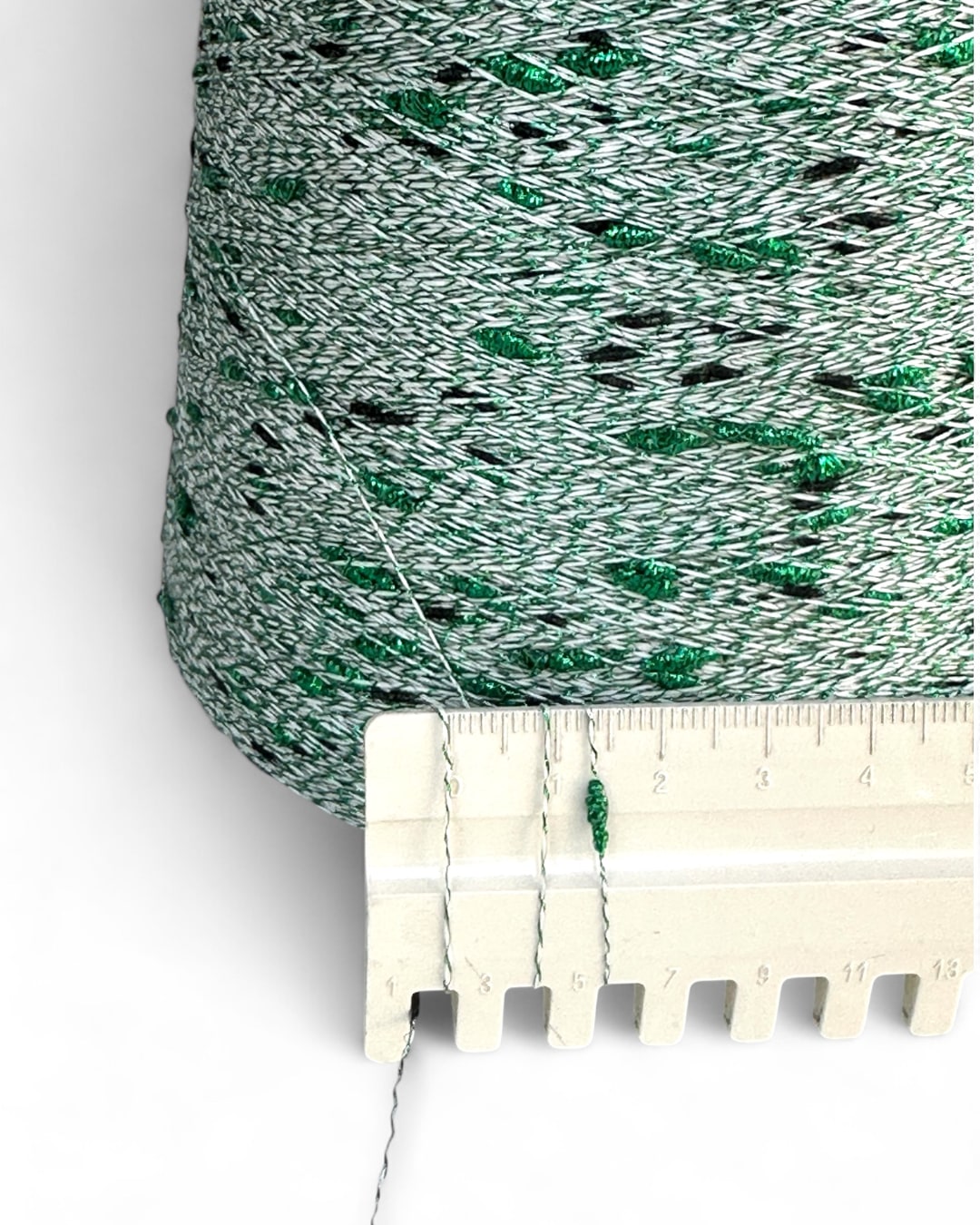 Green and white textured fabric with a ruler for scale on a white background