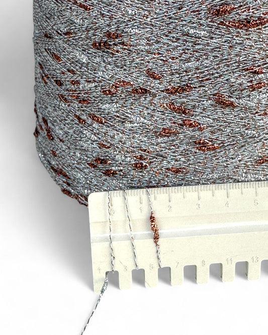 Textured fabric roll with a ruler for scale on a white background