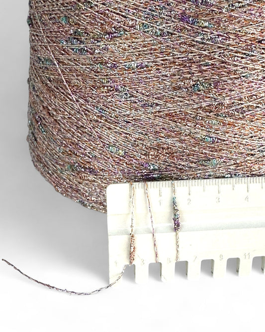 Close-up of a spool of multicolored thread with a measuring tape below.
