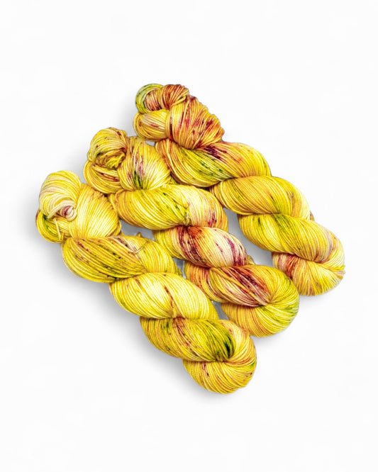 Hand-dyed merino wool yarn “Limoncella”, 300 m / 100 g, sunny yellow base with speckles.