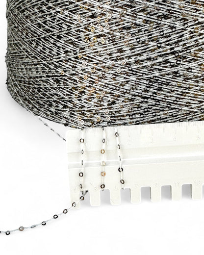 Close-up of Gilded Ash with ruler — light yarn and dark sequins with champagne shimmer