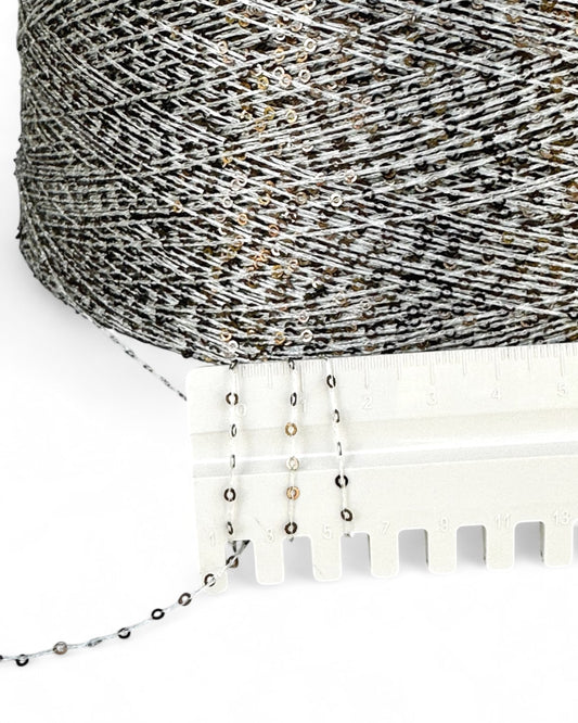 Close-up of Gilded Ash with ruler — light yarn and dark sequins with champagne shimmer