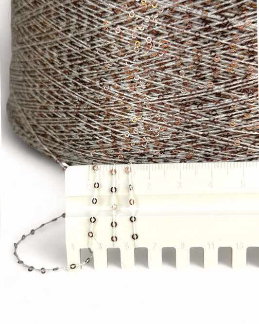 Close-up of copper sequin yarn with ruler