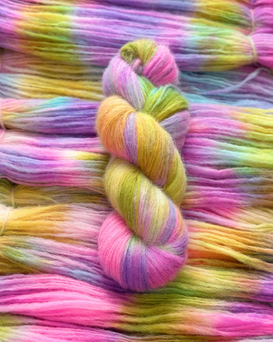 Soft and luxurious yarn blend featuring super baby alpaca, merino wool, and nylon. With 400m per 100g, this variegated yarn showcases beautiful shades of pink, purple, yellow, and green.